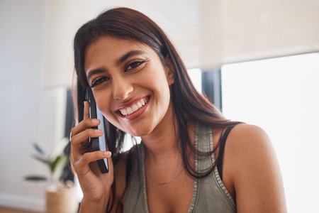 Woman, smile and phone call in home portrait for communication, conversation or talking with happiness. Girl, smartphone and happy in living room, lounge or house for networking on phone in Mumbaiの写真素材