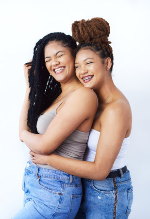 Be happy, it looks beautiful. Studio shot of two beautiful young women posing against a grey background.の写真素材