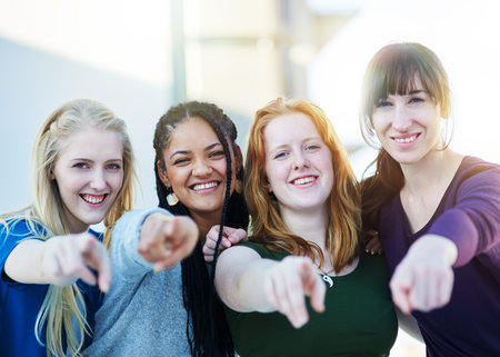 Portrait of a group of women pointing their fingers forward together.の写真素材