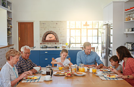 Family first, everything else second. a multi generational family enjoying breakfast together at home.の写真素材