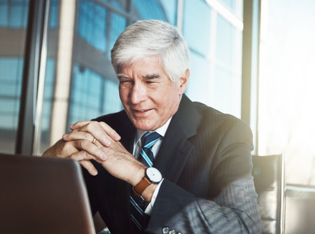 Good work is pleasing to the eye. a mature businessman working on his laptop in the office.の写真素材