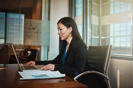 Theres nothing she cant do. a mature businesswoman working on her laptop in the office.の写真素材
