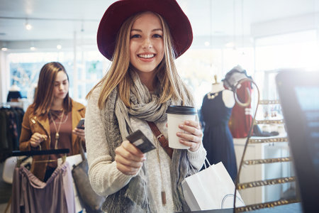 a young woman ready to pay for her goods in a clothing store.の写真素材