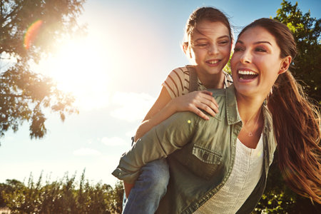 Making her childhood a fun-filled one. a mother and her daughter bonding together outdoors.の写真素材