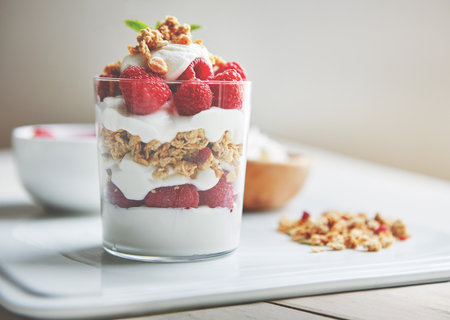 Get a health boost at breakfast. of granola, yoghurt and berries in a glass and on a plate.の写真素材