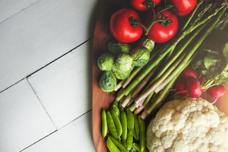 Eat them daily for optimal nourishment. a variety of fresh produce on a wooden chopping board.の写真素材