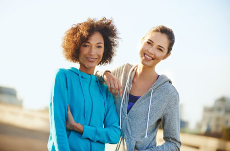 We just beat our best running record. Portrait of two female joggers standing in the road before a run through the city.の写真素材