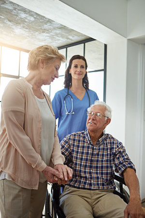 Ill be here the whole time. a nurse standing with a senior couple in their retirement home.