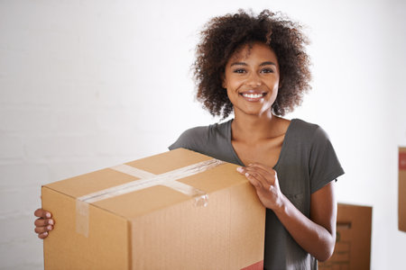 Heres to a new start. Shot of a young woman moving into her new house.の写真素材