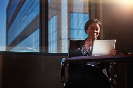 Sheer persistence is the difference between success and failure. a young woman using her digital tablet at her desk.の写真素材