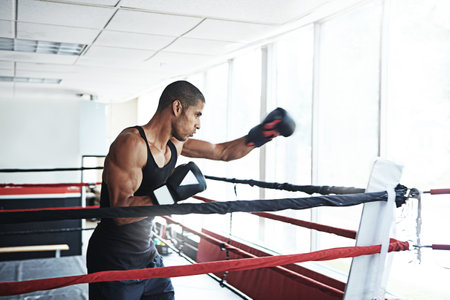 Nothing maximizes potential more than practice. a young man training in a boxing ring.の写真素材