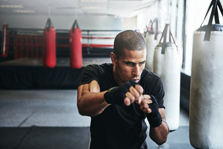 Mama raised a fighter. a kick-boxer training in a gym.
