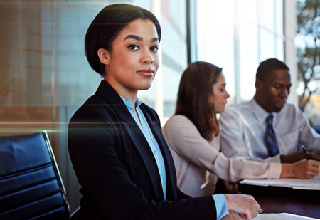 I have full confidence in my team. Cropped portrait of a young businesswoman sitting in a meeting with her boardroom.の写真素材