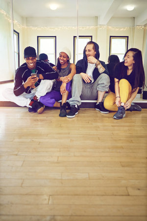 Join a dance class and become part of the family. a group of young friends hanging out in a dance studio.の写真素材
