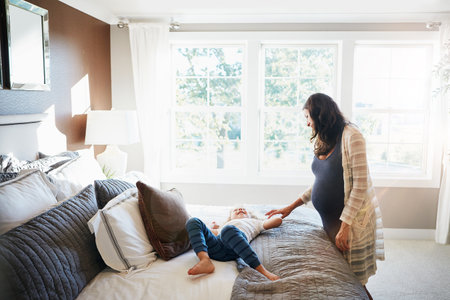 The joy that kids bring is beyond measure. a pregnant woman bonding with her little son at home.の写真素材