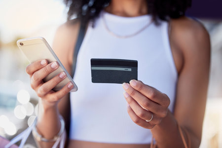 Shopping, credit card and phone for woman with ecommerce, information and confirmation. Online payment, banking and membership for girl retail customer at a mall while checking debit scoreの写真素材