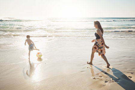 Fun times on the beach. a young woman spending the day at the beach with her son.の写真素材