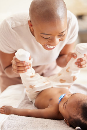 Lets get you into another cute outfit. Shot of a mother changing her baby daughters clothing at...