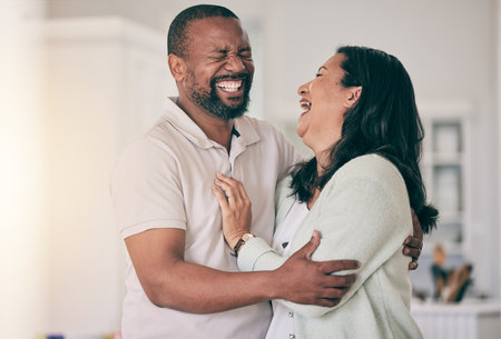 Senior black couple, home and laugh together with hug, happiness or relax for funny memory with love. Black man, woman and mature in house for embrace, comic time or bonding for comedy, happy or careの写真素材