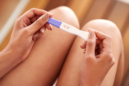Her life is about to change. a woman holding a pregnancy test thats positive.の写真素材
