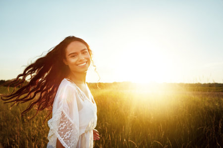 Fresh air never felt so good. Portrait of an attractive young woman standing outside in a field.の写真素材