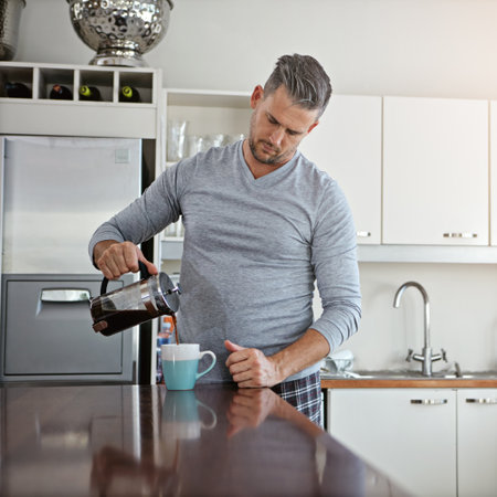 Freshly brewed first thing in the morning. a man drinking coffee in the morning at home.の写真素材