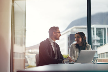 Working through their business process. two office businesspeople having an office meeting.の写真素材