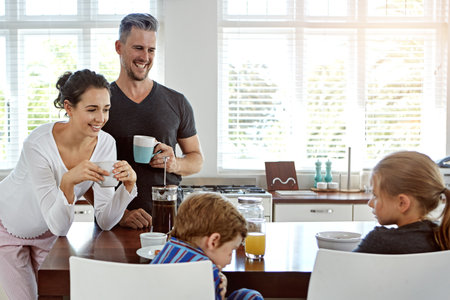 They are proud parents. a family having breakfast together.の写真素材