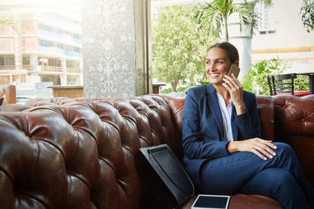 Shes always building on her success. a young businesswoman talking on a cellphone.の写真素材