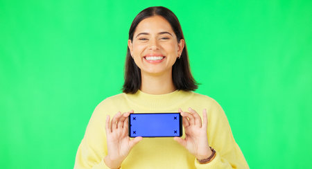Happy woman, phone and mockup on green screen with tracking markers for advertising against studio...