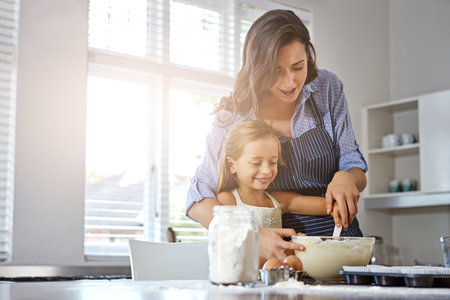 Life is what you bake it. a mother and her daughter baking in the kitchen.の写真素材