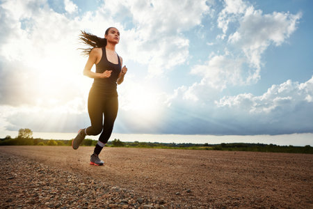 Run, run and run some more. a fit young woman out for a run on a beautiful day.の写真素材