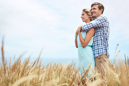 Ill never let you go. a young couple in a field on a sunny day.の写真素材