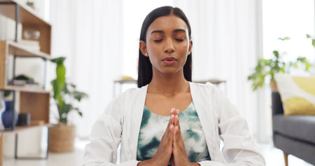 Zen woman calm meditation and breathing sitting alone on floor in living room. Tranquil, bliss, young girl daily spiritual detox for stress relief, peace, serene and chakra, yoga, relax and unwind.の写真素材