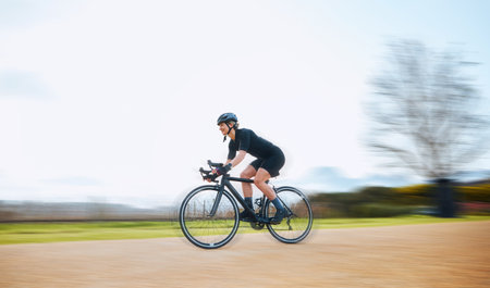 Cycling, motion blur and fitness with woman in nature and mockup for speed, workout and challenge. Exercise, fast and travel with female cyclist riding on bike for journey, adventure and cardioの写真素材