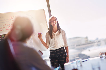 Shes acing this presentation. businesspeople brainstorming in a boardroom.の写真素材