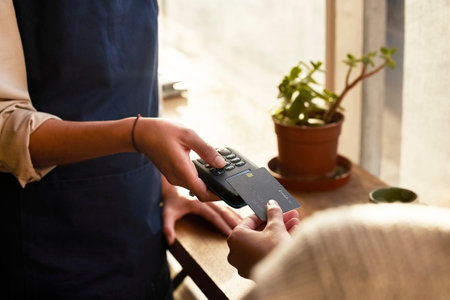 Hand, credit card and pos terminal in a coffee shop for payment by a customer to a waitress for...