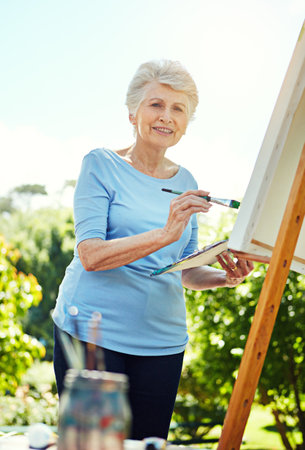Nature is my inspiration. Cropped portrait of a senior woman painting in the park.の写真素材
