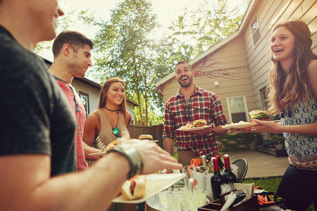 Barbecue bash. a group of friends having lunch in their backyard.の写真素材