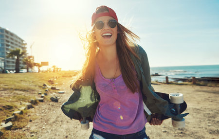 Enjoying every minute of summer skateboarding. a young woman hanging out on the boardwalk with her...