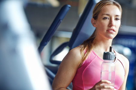 Taking a quick break between workouts. A young woman resting after her workout.