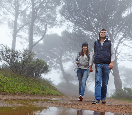 Adventure is out there. Full length shot of a young couple hiking through a forest.