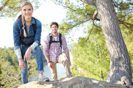Not much further to go...A young couple hiking and climbing up the mountainside together.