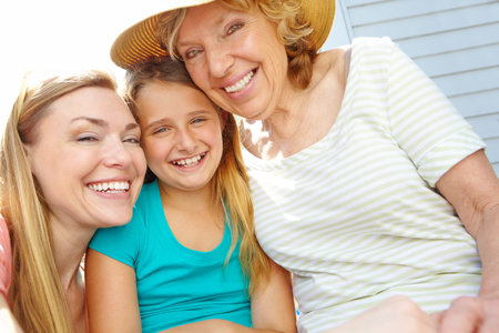 Relaxing in the backyard. A cute young girl spending time in the summer sun with her mother and...