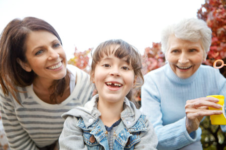That was so much fun. Portrait of a little girl having fun with her mother and grandmother.
