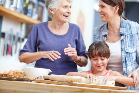 The women of the family love baking. a three generational family baking together.の写真素材