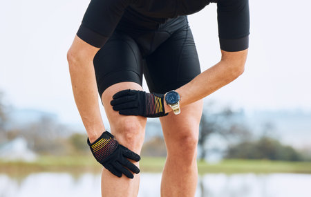 Fitness, knee pain and sports injury by man cyclist in nature for training, exercise and morning...