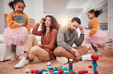 Family, girl playing and parents with stress, frustrated or in living room with a headache or burnout. Mother, father or female child with toys, busy or fast speed in lounge, home or hyper active kidの写真素材