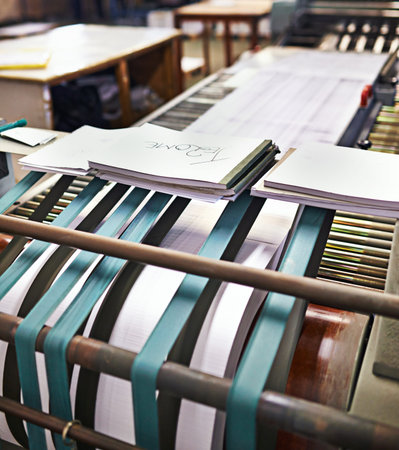 Hot of the press. Detail shot of the workings of a printing factory.