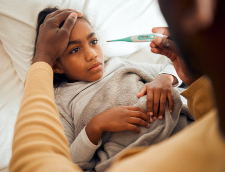 Sick, girl and dad checking thermometer of ill kid or daughter lying on a bed feeling sad. Concern, care and parent in bedroom with worried child with flu, cold or fever giving her supportの写真素材